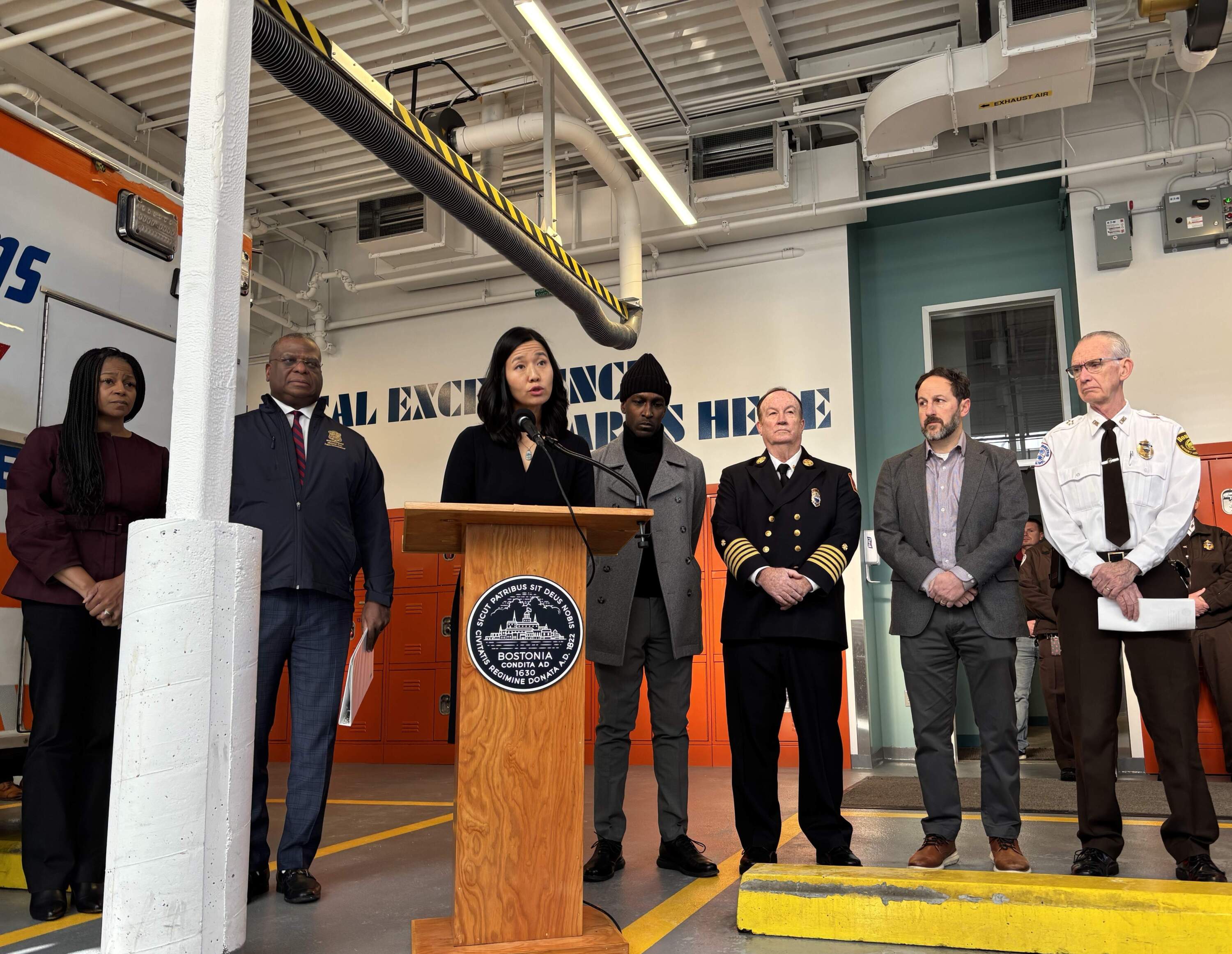 Mayor Michelle Wu, center, speaks at a press conference about public safety in West Roxbury along with Police Commissioner Michael Cox, second from left. (Eve Zuckoff/WBUR)
