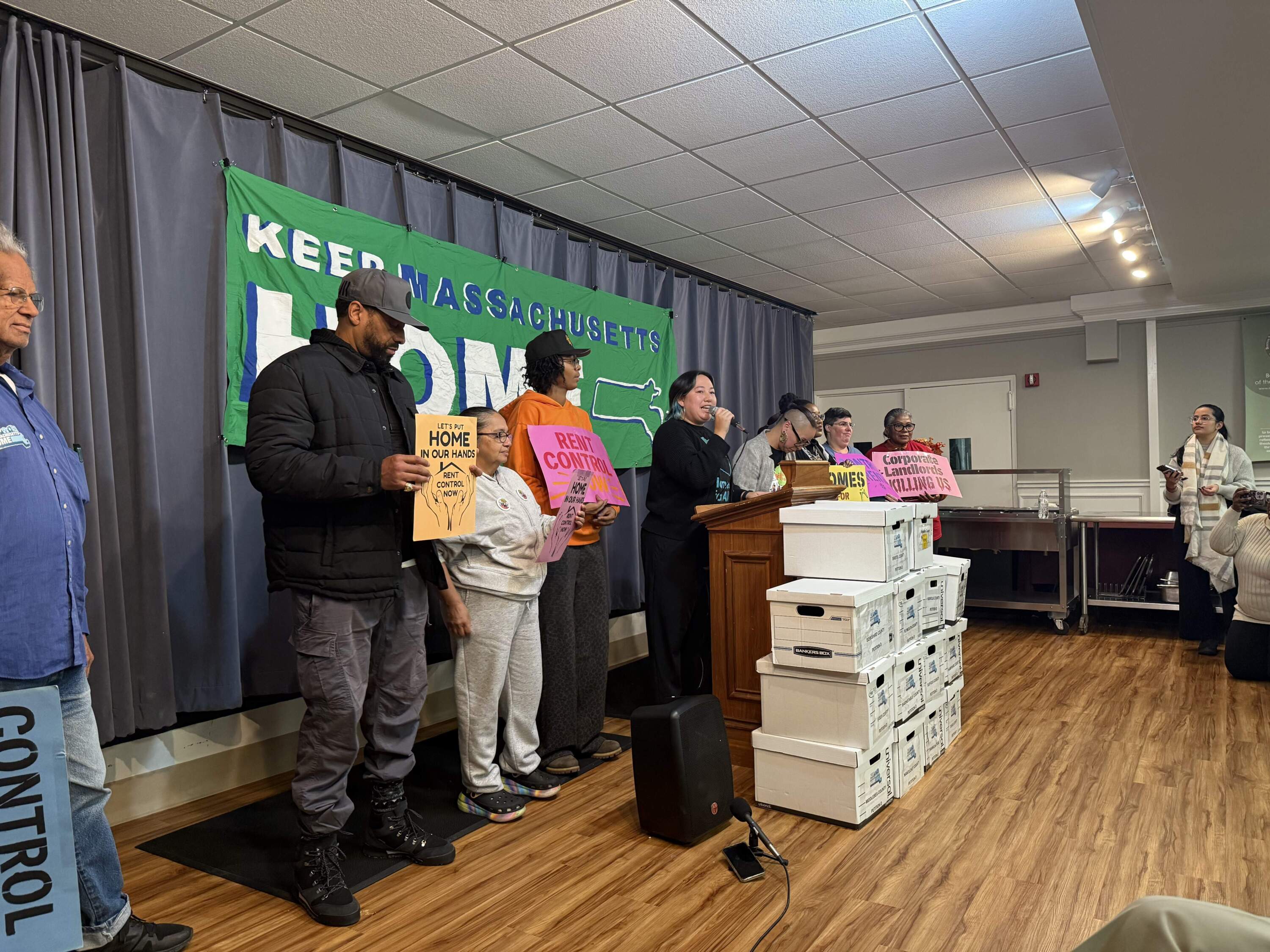 Carolyn Chou, the executive director of Homes for All Massachusetts, speaks at a rally on Tuesday, Dec. 2, in support of a ballot question that would implement rent control in Massachusetts. (Chris Van Buskirk/WBUR)