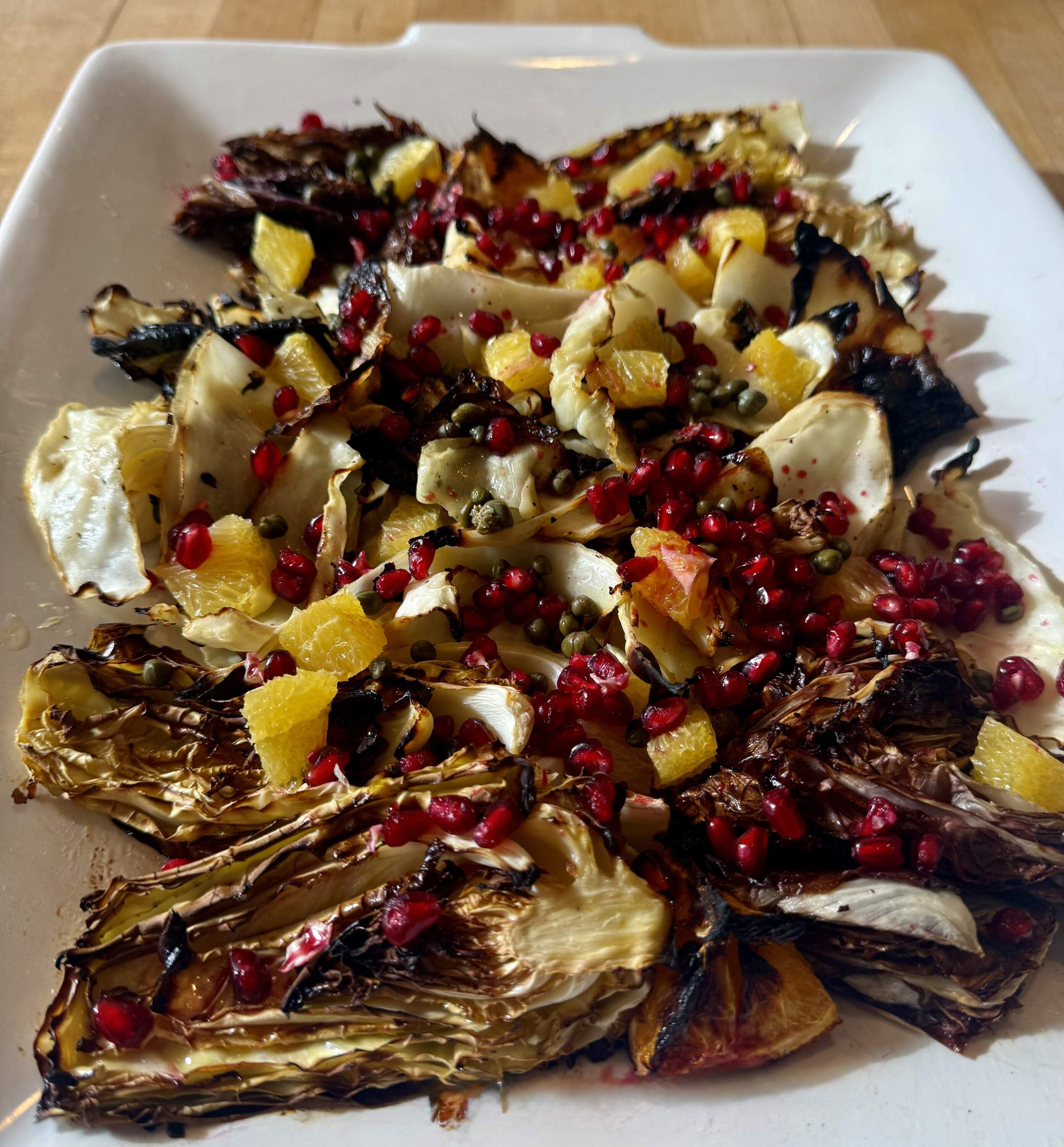Roasted cabbage with burnt oranges, pomegranate seeds and capers. (Kathy Gunst/Here & Now)