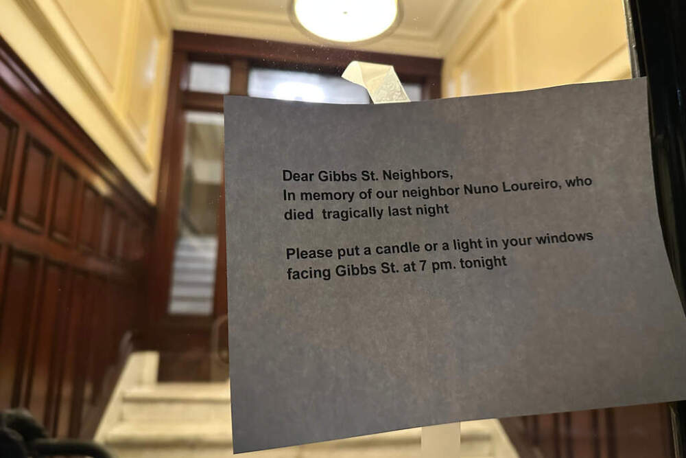 A notice encouraging neighbors of MIT professor Nuno F.G. Loureiro to display candles in their windows to honor his life is taped to an apartment door in Brookline. (ALeah Willingham/AP)