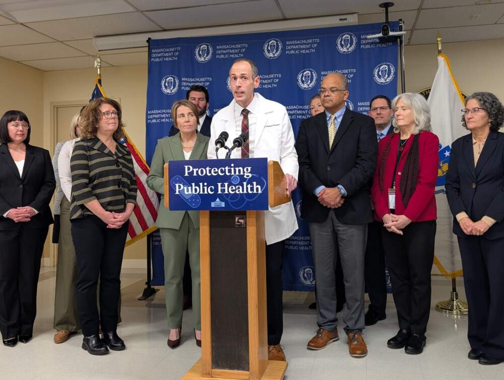 Dr. Robbie Goldstein speaks about vaccines at a press conference with Gov. Maura Healey (left) and doctors who gathered at the state Department of Public Health on Dec. 3, 2025. (Priyanka Dayal McCluskey/WBUR)
