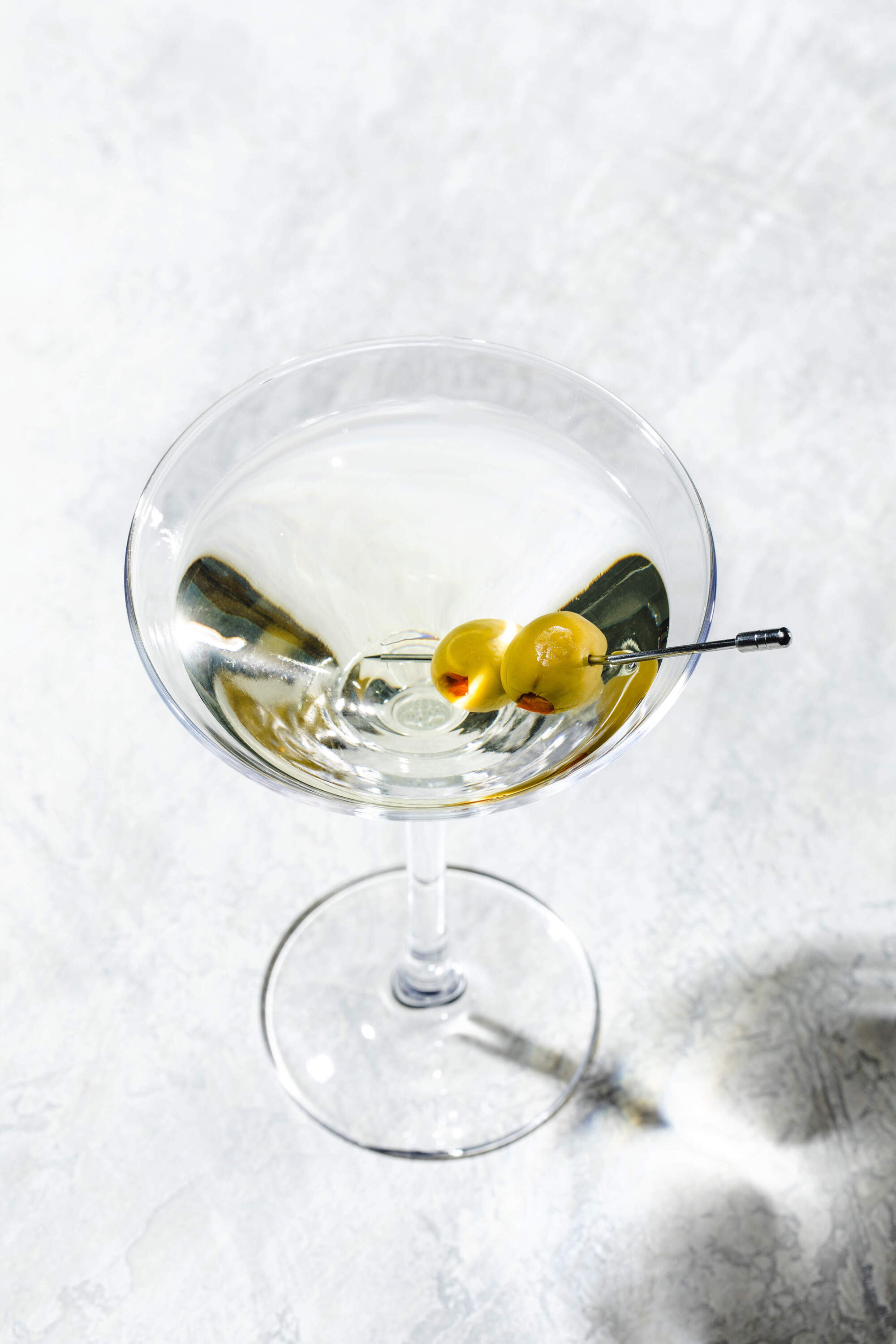 A perfectly clear, chilled Classic Martini in a coupe glass.