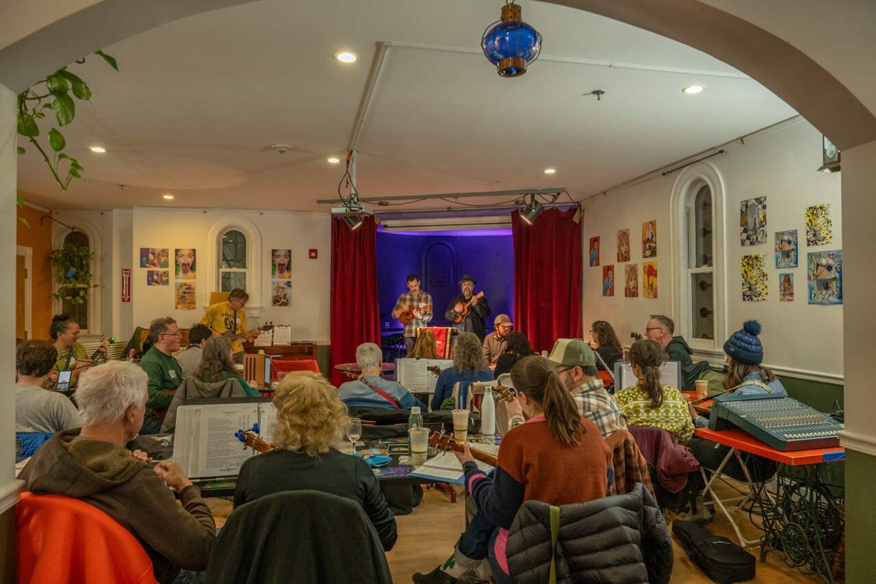 Dozens of people gathered at a meetup of the Strummerville Ukulele Club in Somerville. (Sharon Brody/WBUR)