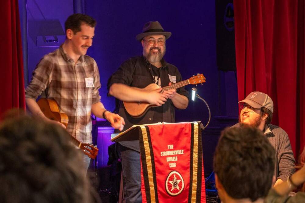 Nick Howarth, left, and John Soares lead a meetup of the Strummerville Ukulele Club (Sharon Brody/WBUR)
