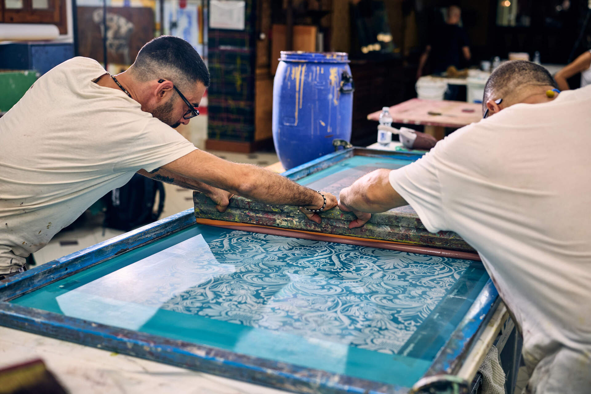 Two men work on hand-painted wallpaper and tiles in the decoration workshop at San Patrignano. (Wilson Santinelli for WBUR)