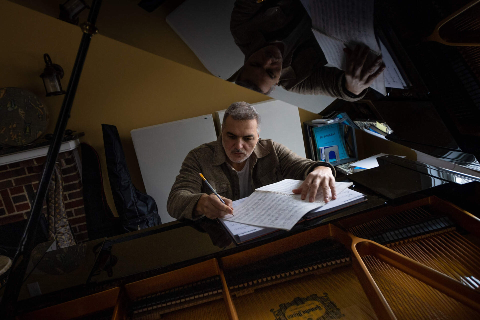 Latin jazz musician Leo Blanco composes music in his studio in Medford. Blanco, a Venezuelan living in the Boston area, said he's conflicted about the U.S.' intervention in Venezuela. (Jesse Costa/WBUR)