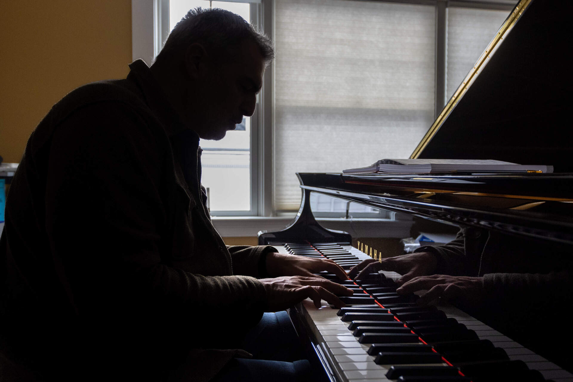 Leo Blanco plays the piano at his home studio in Medford. (Jesse Costa/WBUR)