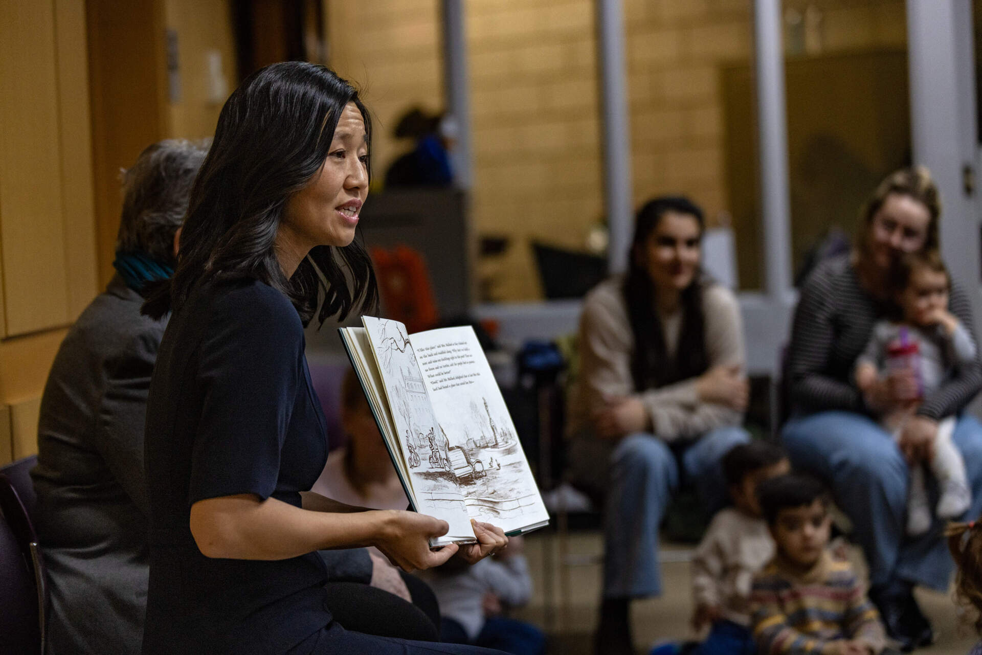 Michelle Wu reads aloud Robert McCloskey’s “Make Way for Ducklings” to children during a story time event at the Boston Public Library's Brighton branch. (Jesse Costa/WBUR)