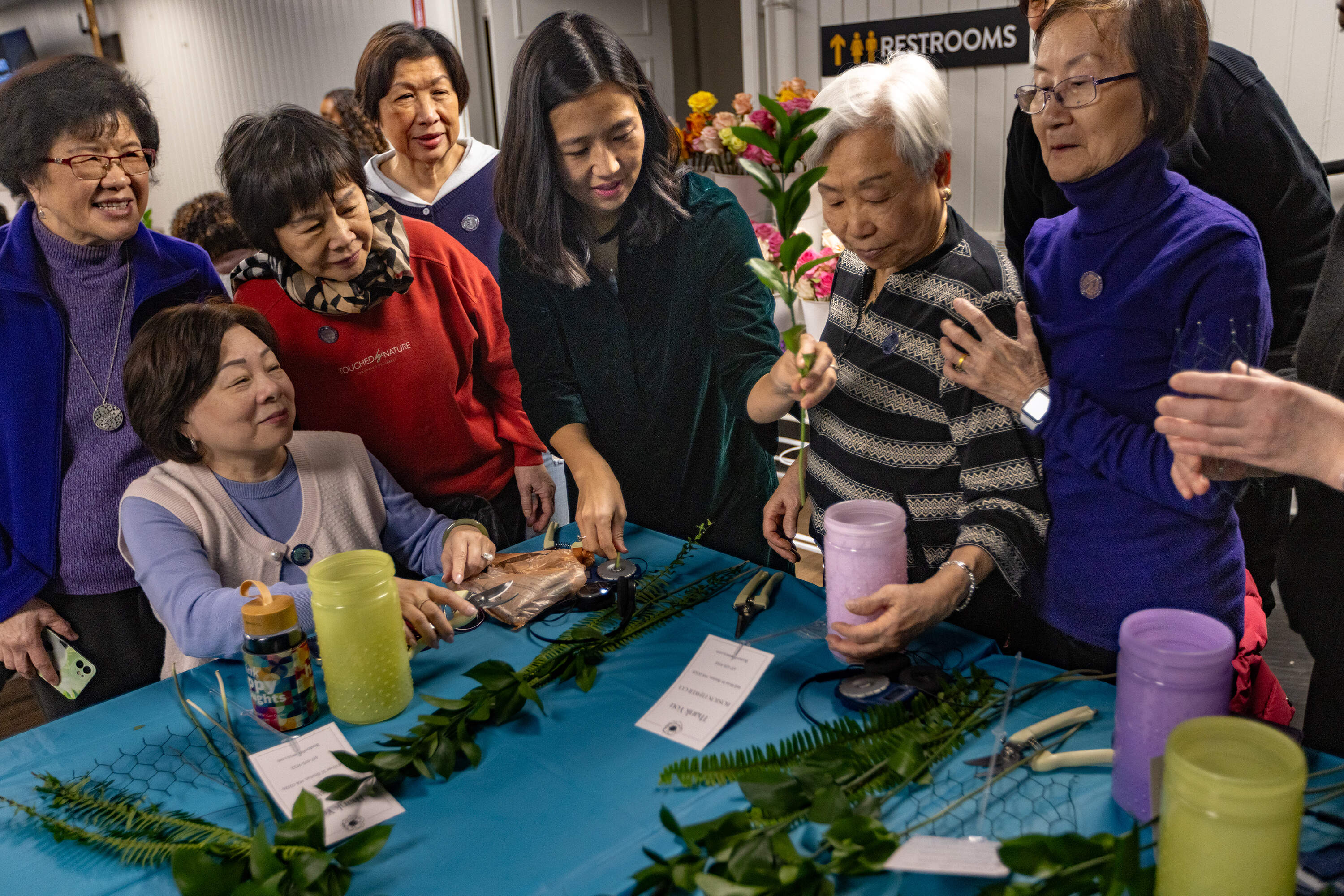 Michelle Wu takes part in creating a floral arrangement with South End residents at the “Bloom Boston: A Floral Design Event” at Union Church. (Jesse Costa/WBUR)