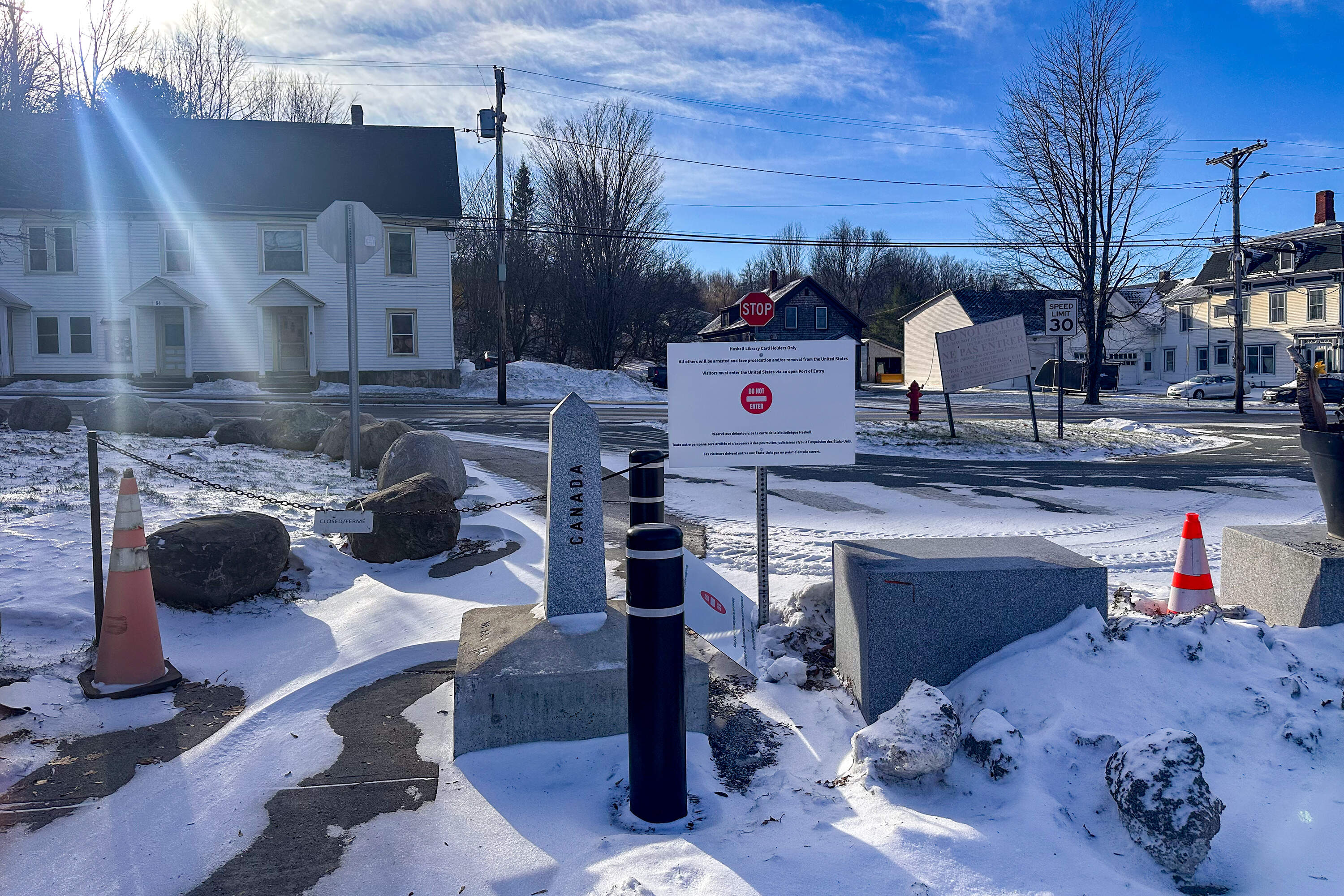 Signs beside the Haskell library point toward Canada, warning people not to step onto U.S. territory. (Simón Rios/WBUR)