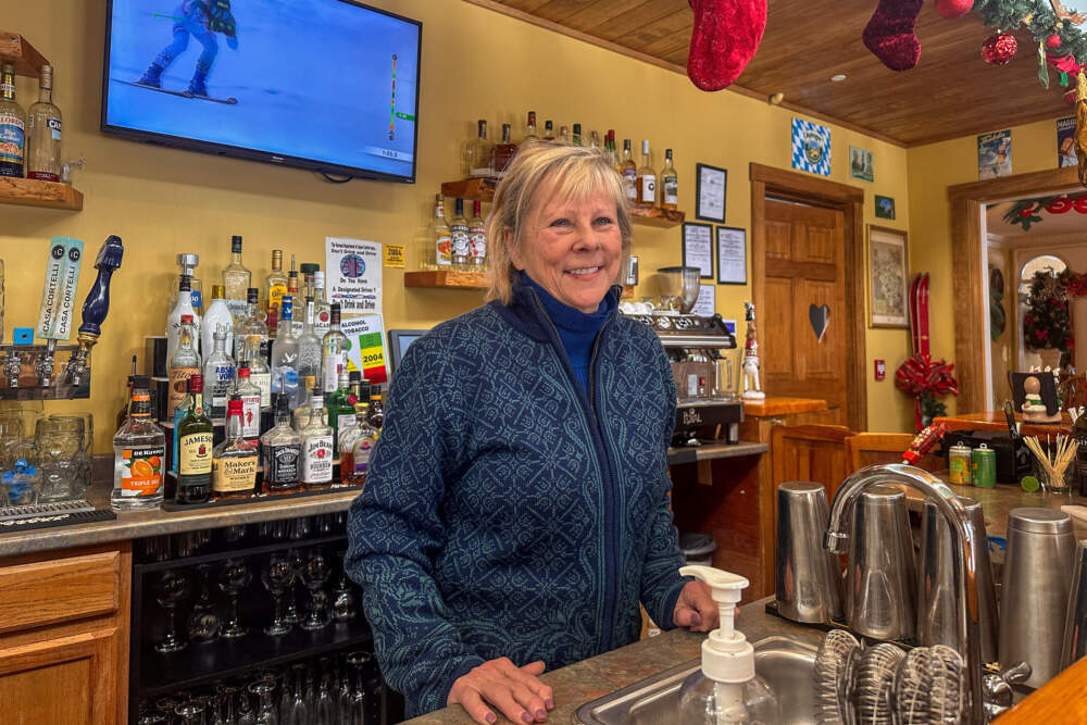 Inn owner Paula Halbedl in Derby, Vermont, stands behind the bar. She counts Border Patrol agents among the regulars there. (Simón Rios/WBUR)