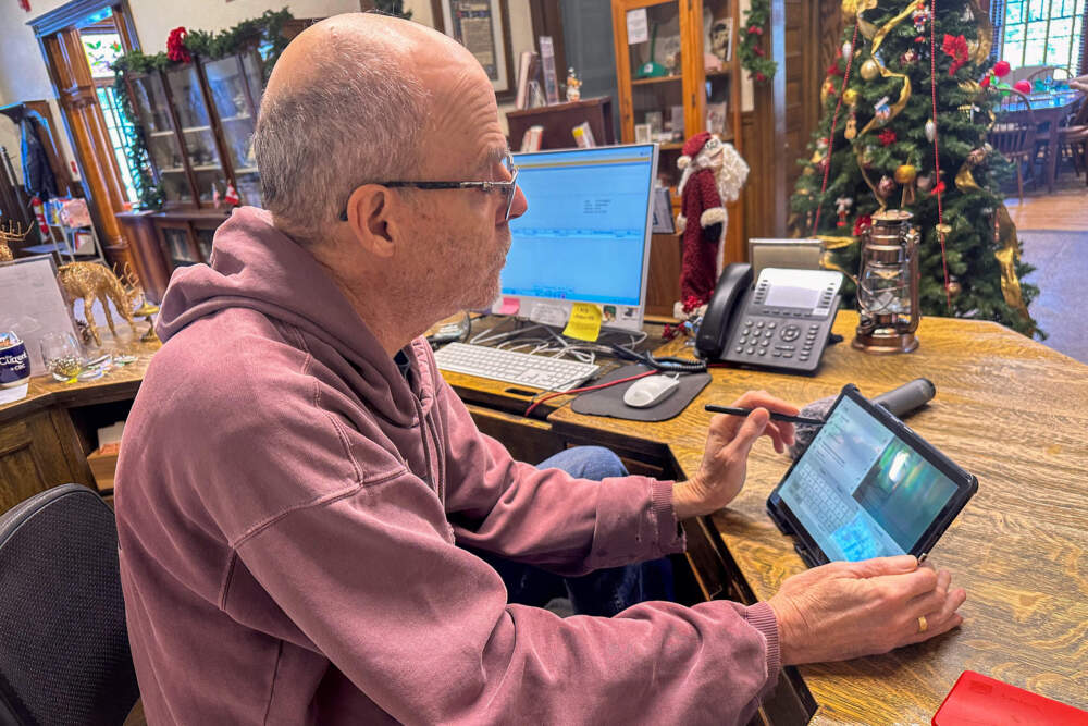 Library volunteer Peter Lepine pulls up Google Maps to see how GPS directions might lead you to a point of entry along the border. (Simón Rios/WBUR)