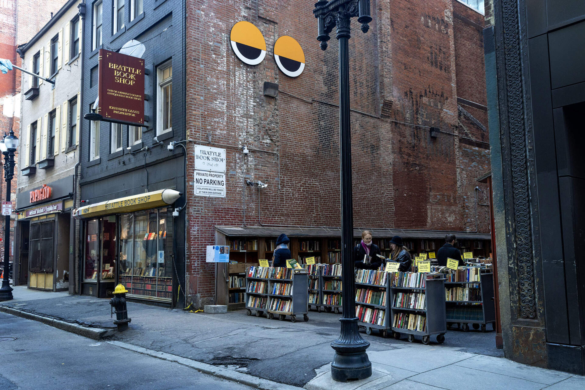 The eyes of Winteractive art installation "Big Other 2" by Collectif Pierre&amp;Marie look down from Brattle Book Shop's exterior on West Street in downtown Boston. (Robin Lubbock/WBUR)