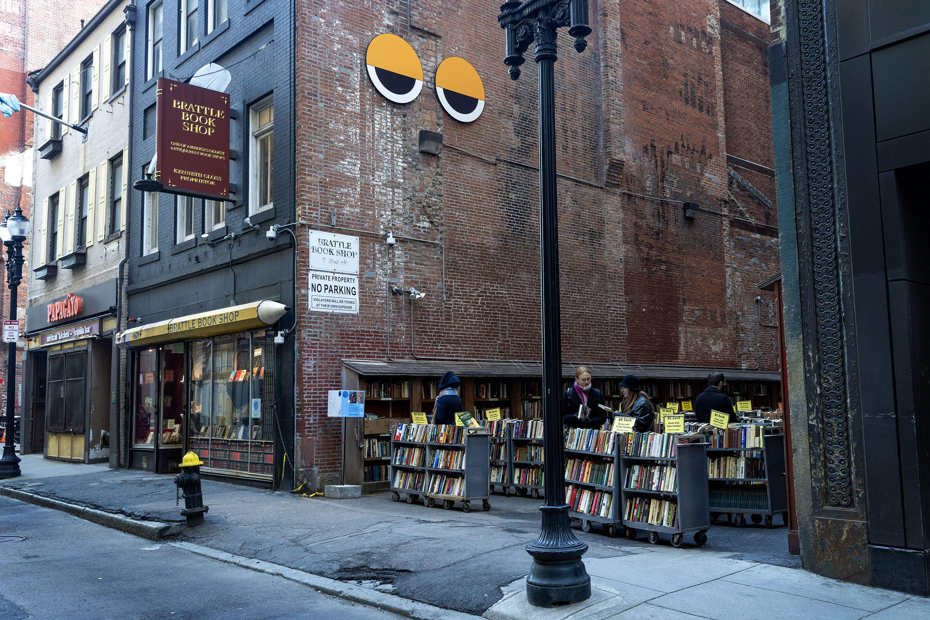 The eyes of Winteractive art installation "Big Other 2" by Collectif Pierre&Marie look down from Brattle Book Shop's exterior on West Street in downtown Boston. (Robin Lubbock/WBUR)