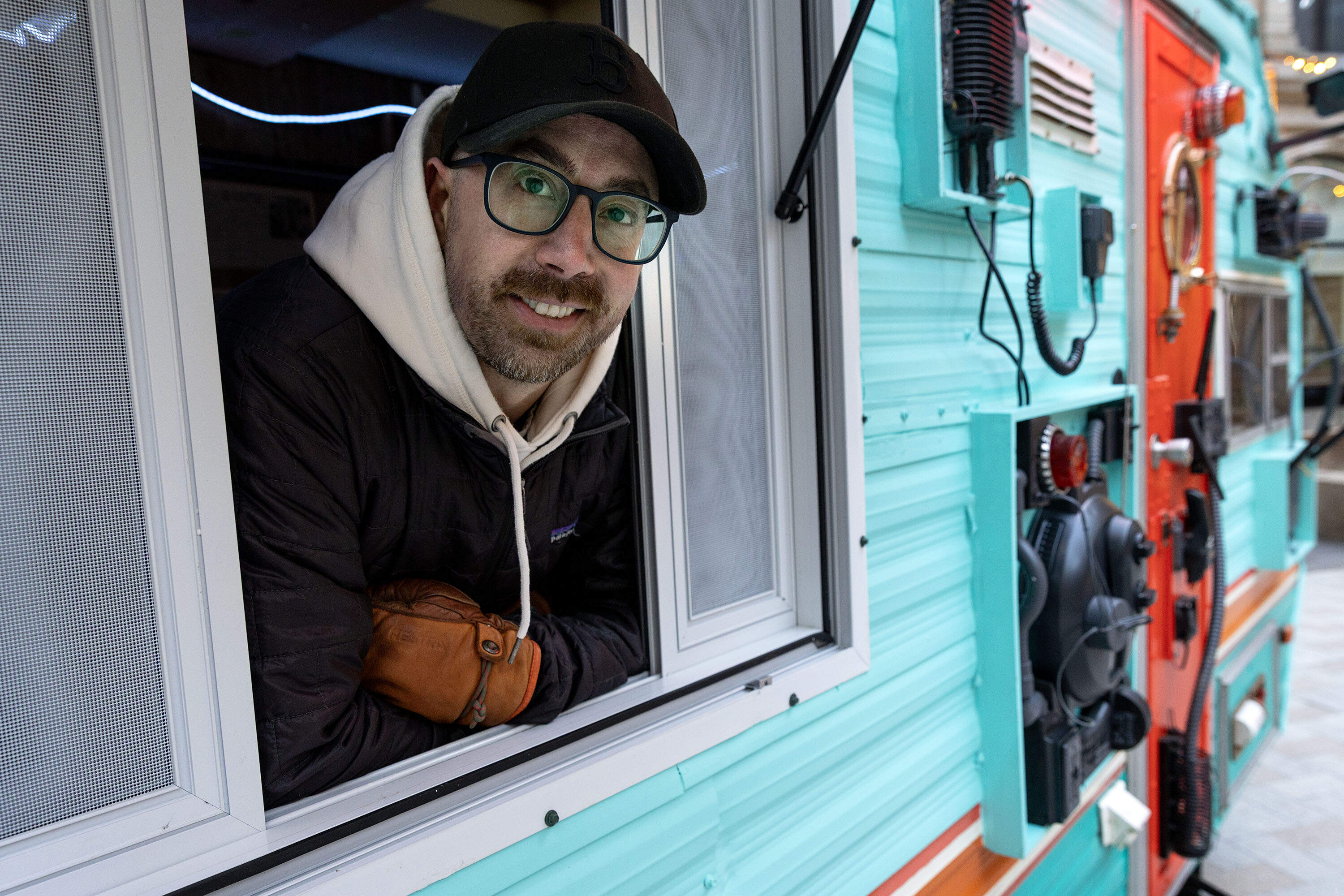 Artist Colin Driesch leans out of the window of "The Bison Observatory" by Individuals Collective. The trailer is currently in Winthrop Square as part of this year's Downtown Boston walkable art experience: Winteractive. (Robin Lubbock/WBUR)
