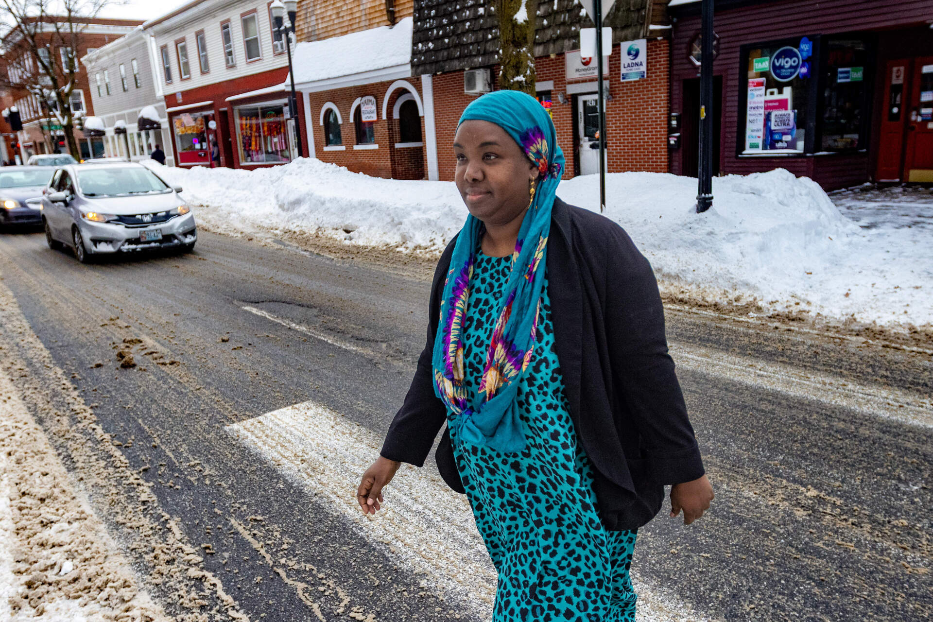 Ifraax Saciid-Ciise, founder and executive director of Ifka Community Services, walks across Lisbon Street to one of the many African-owned businesses in the area. (Jesse Costa/WBUR)