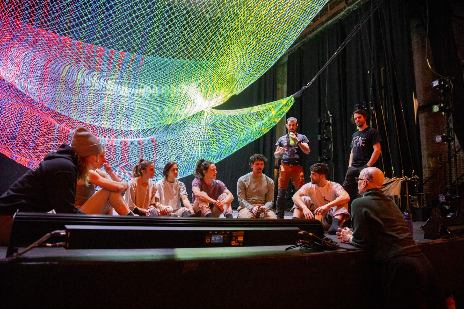 Director and choreographer Rebecca Lazier (right) engages in a post-rehearsal debrief with the show’s dancers and riggers on Jan. 24. (Artemisia Luk/WBUR)