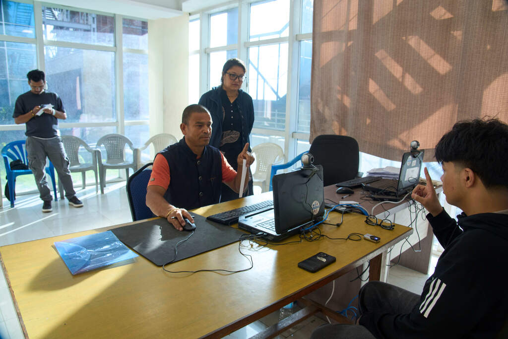 A government officer directs a man to scan biometric data while registering his name on the voter list ahead of election scheduled for March 5, 2026, at an election office in Kathmandu, Nepal, on Oct. 10, 2025. (Niranjan Shrestha/AP)
