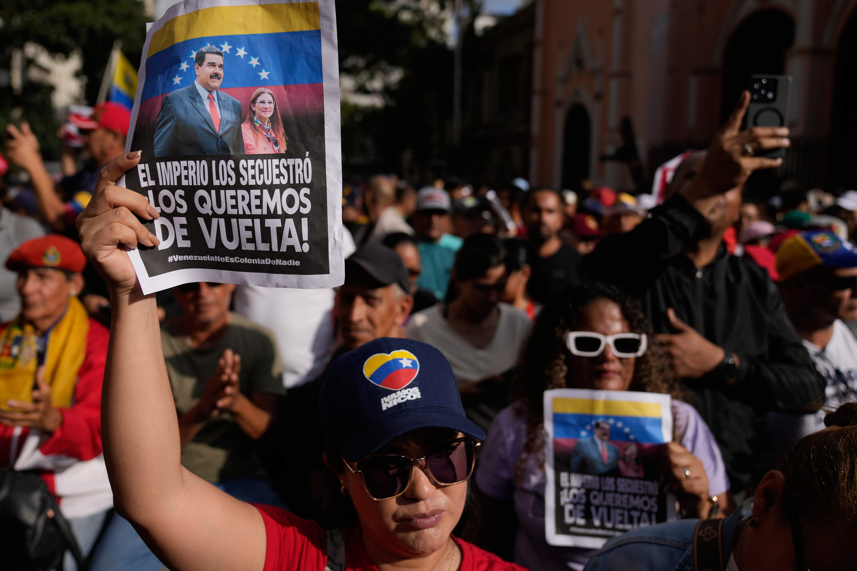 Government supporters hold posters that read in Spanish, "The empire kidnapped them; we want them back," during a protest demanding President Nicolas Maduro and first lady Cilia Flores release from U.S. custody in Caracas, Venezuela, Sunday, Jan. 4, 2026. (Ariana Cubillos/AP)