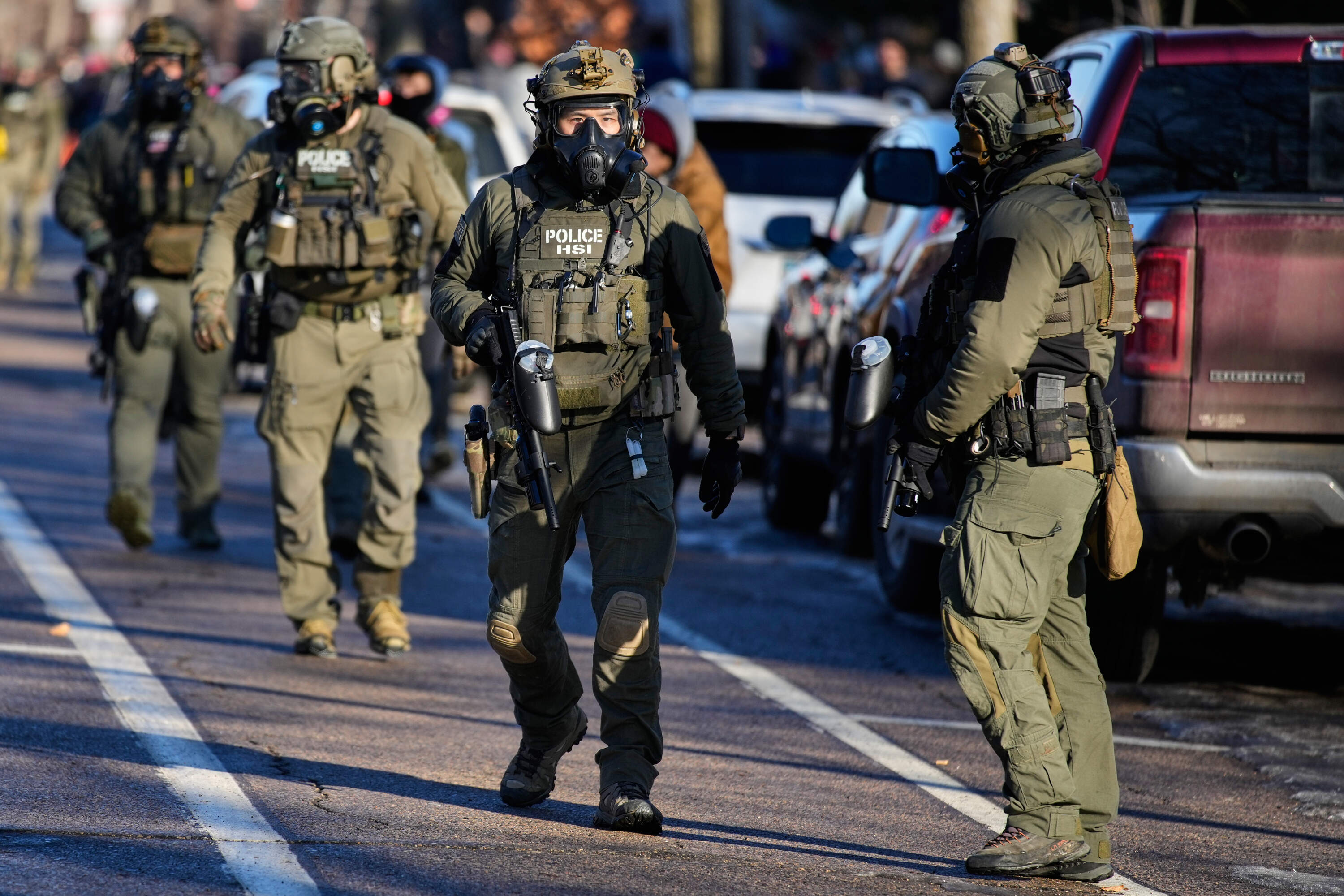 Federal immigration officers are seen near the scene where Renee Good was fatally shot by an ICE officer last week, Tuesday, Jan. 13, 2026, in Minneapolis. (John Locher/AP)