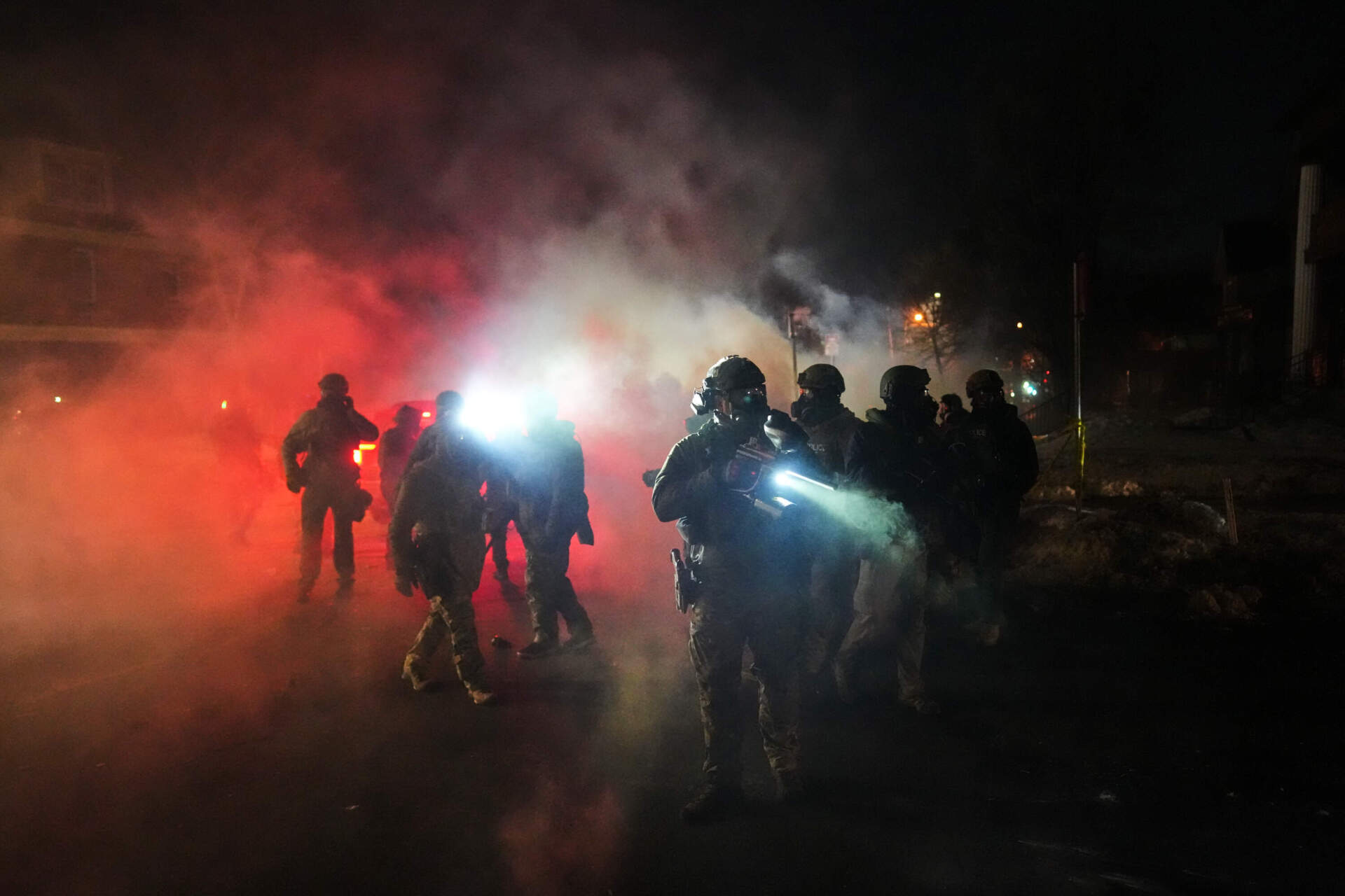 Law enforcement officers stand amid tear gas at the scene of a reported shooting Wednesday. (Adam Gray/AP)