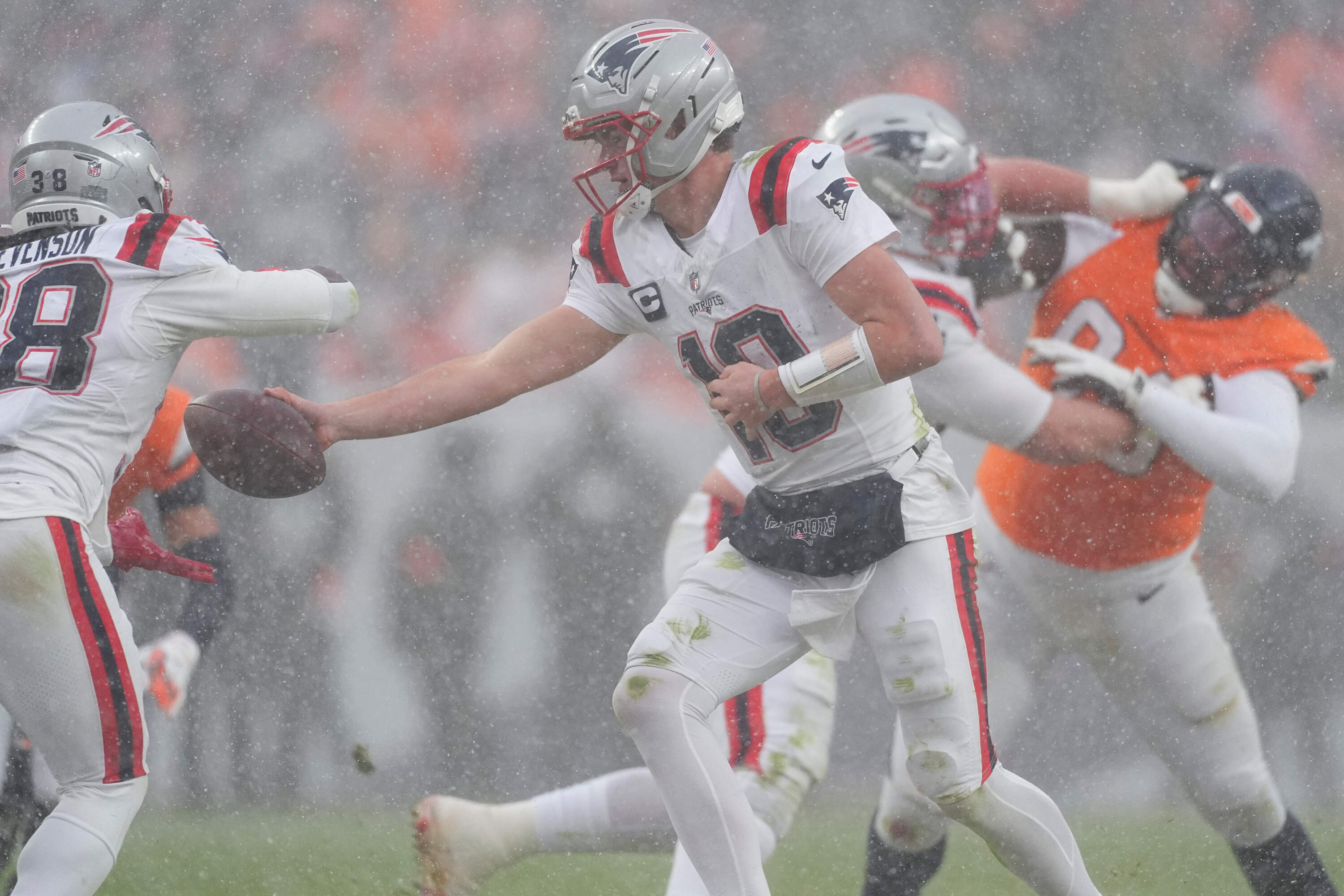 New England Patriots quarterback Drake Maye hands off against the Denver Broncos during the second half of the AFC Championship NFL football game, Sunday, Jan. 25, 2026, in Denver. (David Zalubowski/AP)