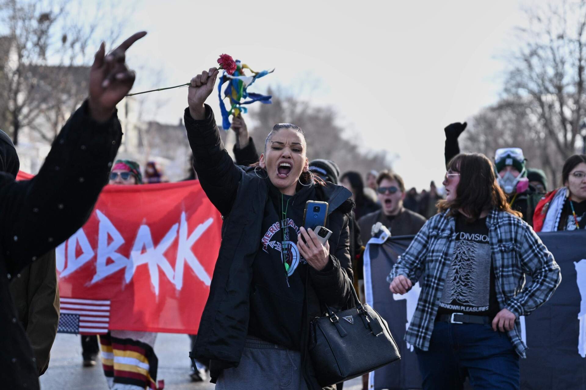 People protest as law enforcement officers attend to the scene of the shooting on Wednesday, Jan. 7, in Minneapolis. (Tom Baker/AP)