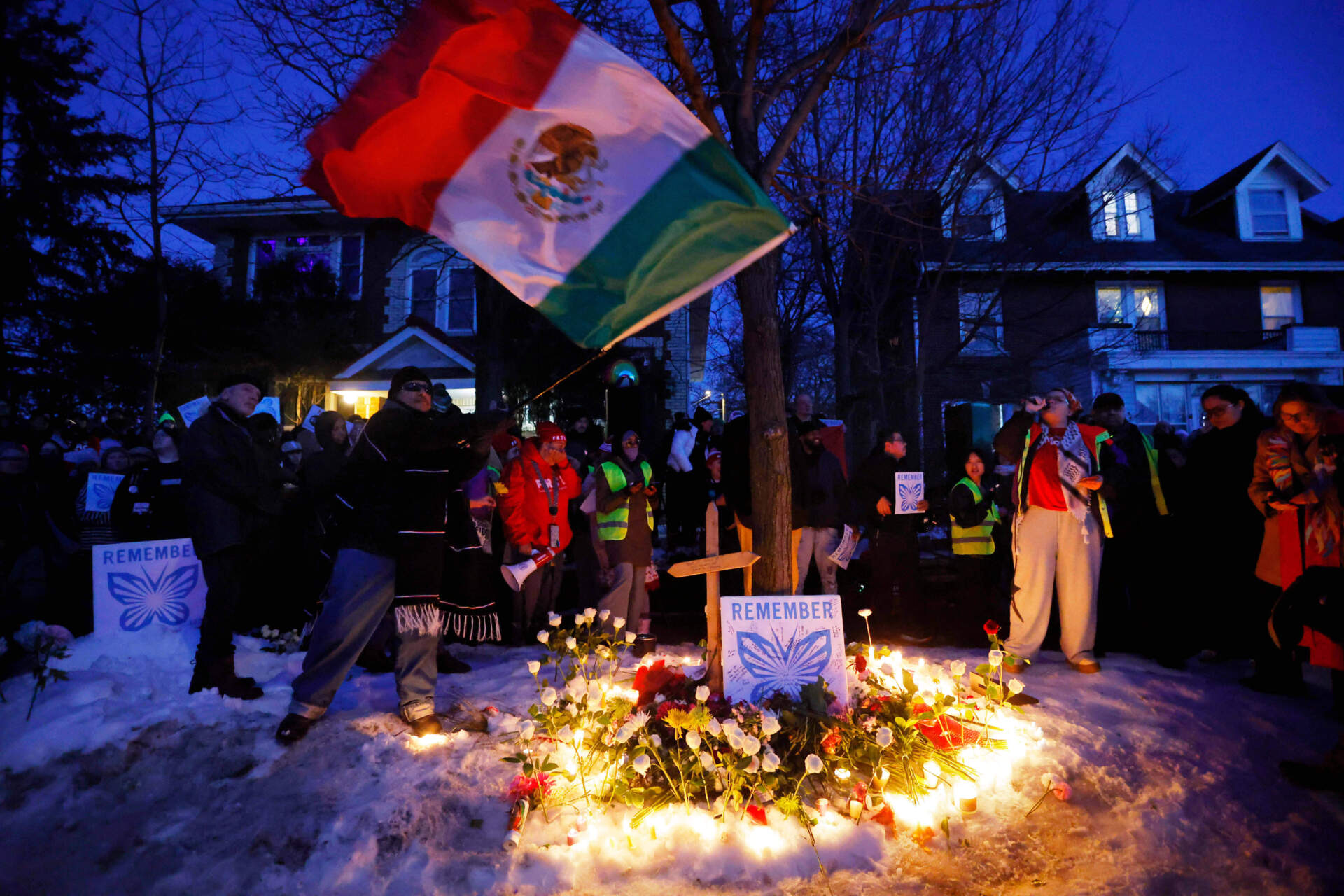 People gather for a vigil after an ICE agent shot and killed a woman earlier in the day. (Bruce Kluckhohn/AP)