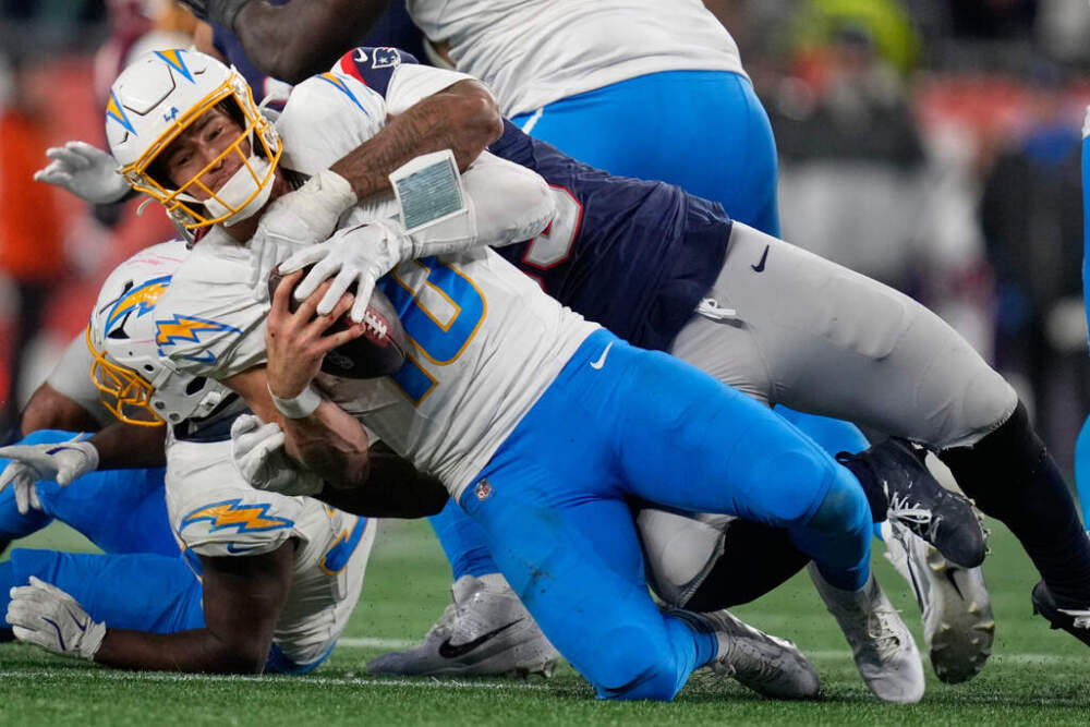 Los Angeles Chargers quarterback Justin Herbert (10) is sacked by New England Patriots linebacker Anfernee Jennings, rear, in the second half of an NFL wild-card playoff football game in Foxborough. (Charles Krupa/AP)