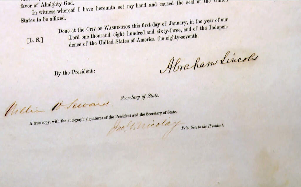 A copy of the Emancipation Proclamation, signed by Abraham Lincoln, his Secretary of State William Seward and his Secretary John Nicolay, sits on display at Christie's during a preview for the "We the People: America at 250" auction. (Joe Frederick/AP)