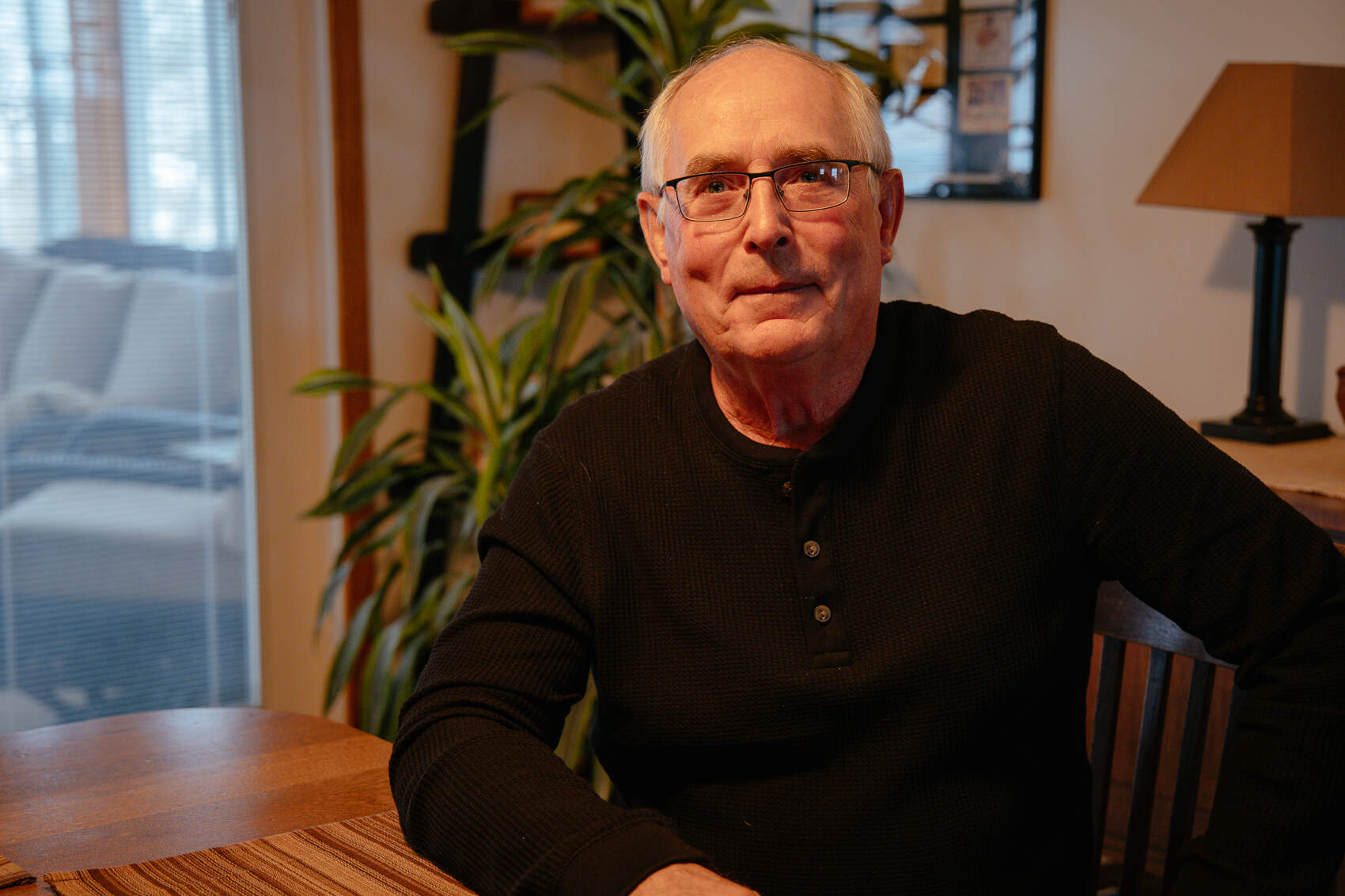 Doug Fuller sits at his dining room table in the middle of his nearly 1,000-acre corn and soybean farm. (Madeleine Charis King/Iowa Public Radio)
