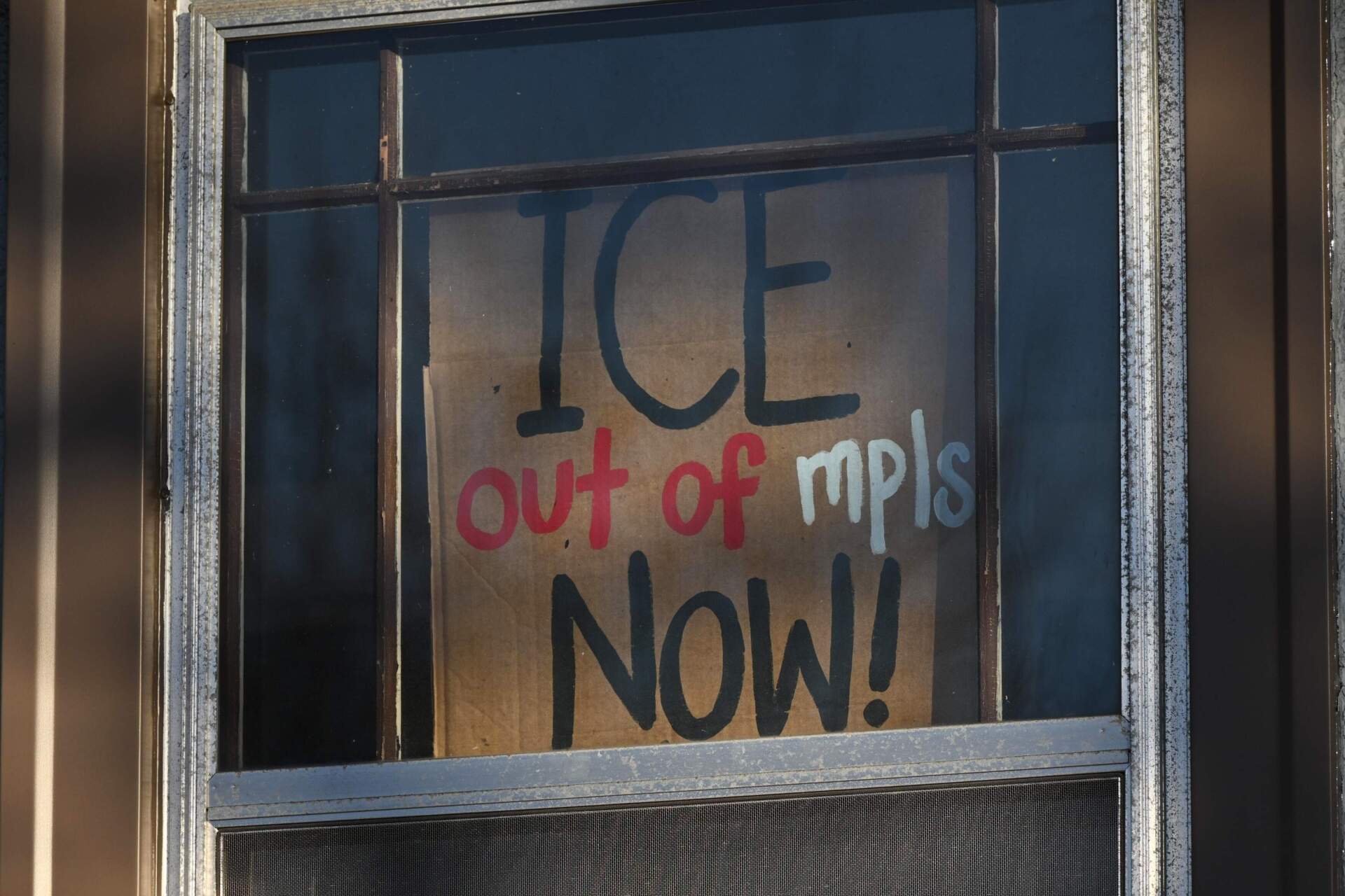 A sign is posted on a residential window near the scene of the fatal shooting on Wednesday. (Tom Baker/AP)