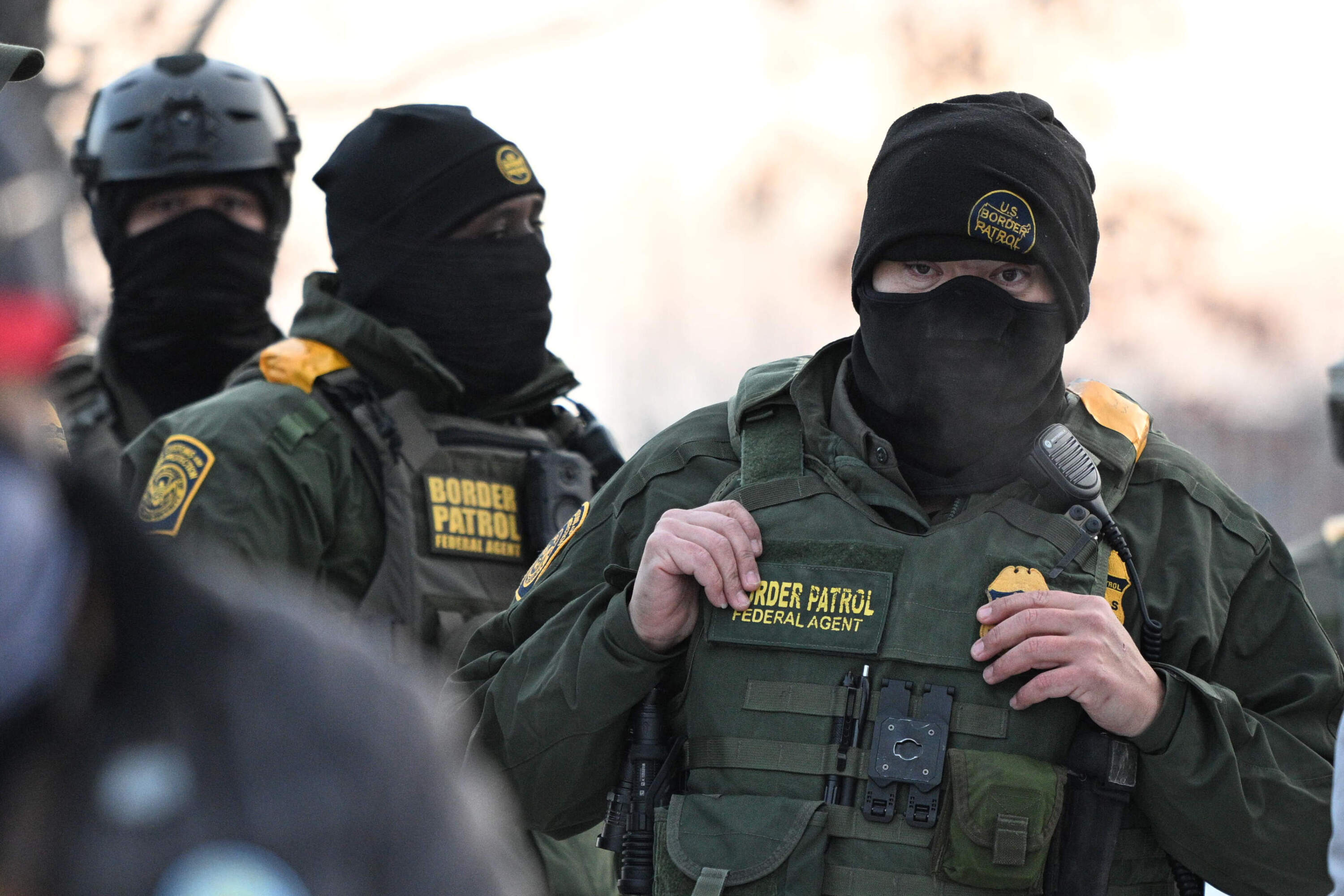 Federal agents look on as protesters gather outside the Bishop Henry Whipple Federal Building, Thursday. (Tom Baker/AP)