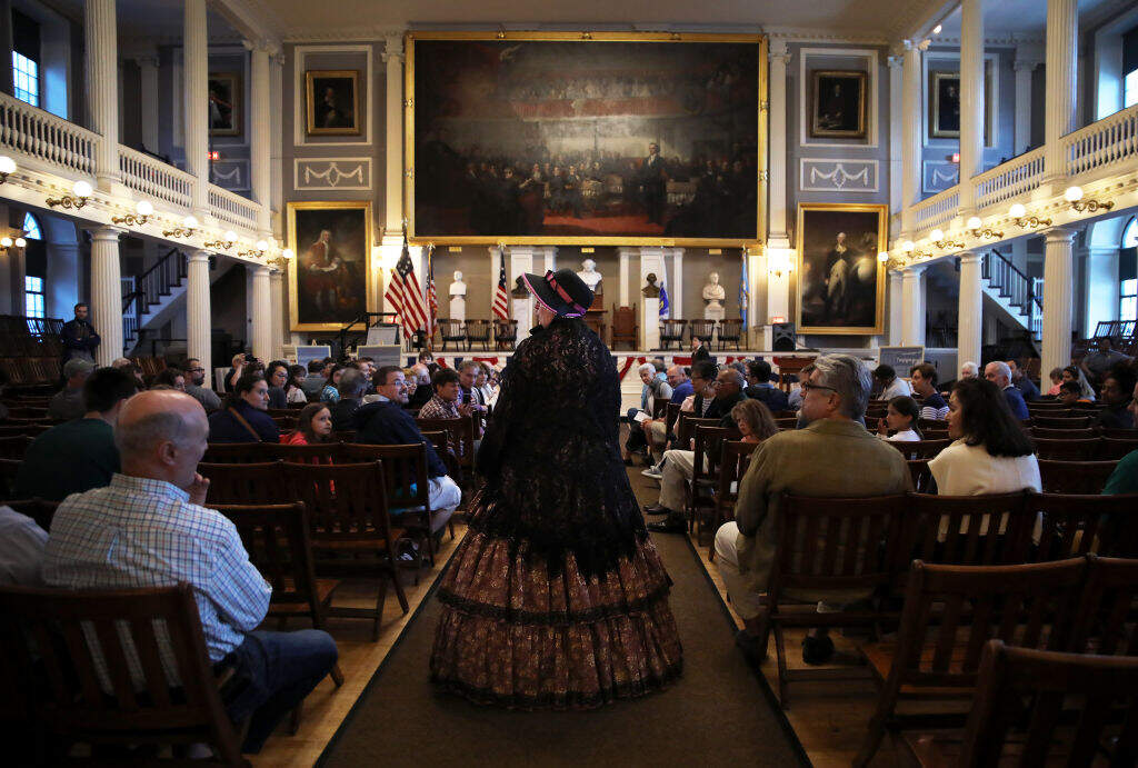 Jocelyn Gould, center, a park guide for the National Parks of Boston, participates in a re-creation of the historic meeting over the fate of runaway slave Anthony Burns at Faneuil Hall in Boston on Aug. 25, 2019. (Erin Clark for The Boston Globe via Getty Images)