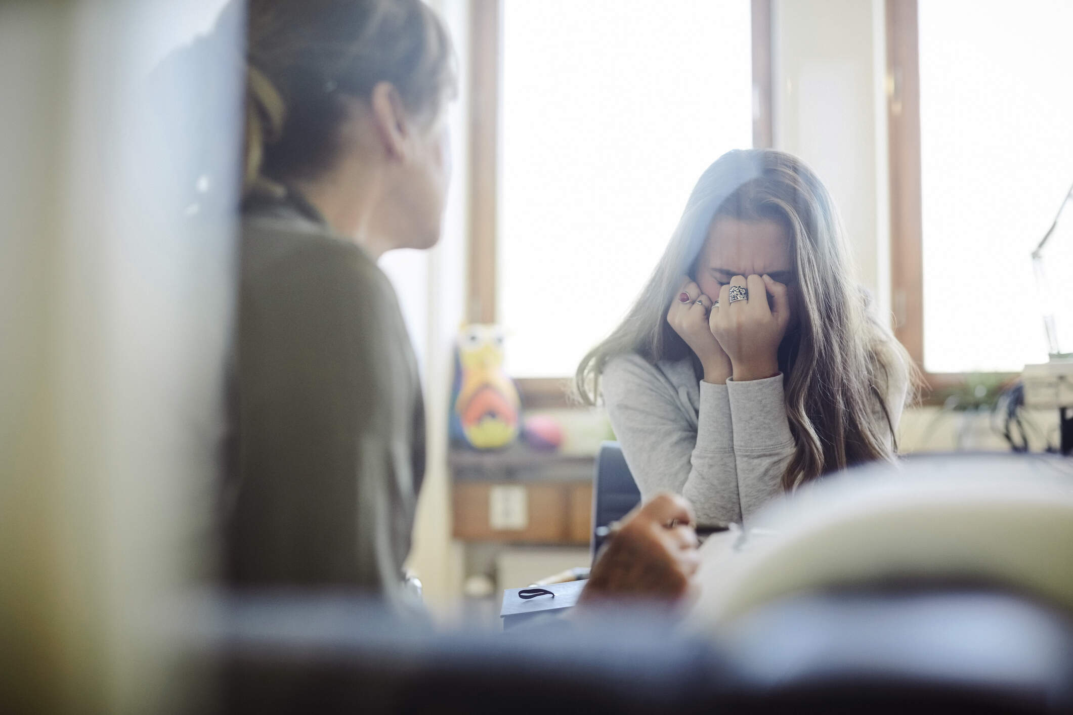 A teenage girl, visibly upset, speaks with a doctor. (Getty Images)