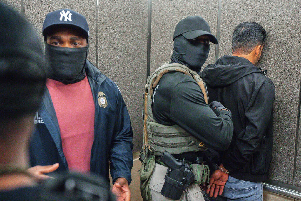  Immigration and Customs Enforcement agents escort a detained immigrant into an elevator after he exited an immigration courtroom, June 17, 2025, in New York. (AP Photo/Olga Fedorova, file)