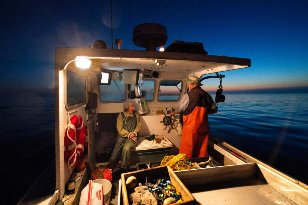 Virginia Oliver, left, talks with her son, Max Oliver, while heading out to sea to catch lobsters at dawn, Aug. 31, 2021. (Robert F. Bukaty/AP)