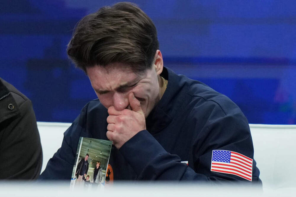 Maxim Naumov holds a photo of his parents while he waits for his scores after competing during the men's short program at the U.S. Figure Skating Championships, Thursday, Jan. 8, 2026. (Stephanie Scarbrough/AP)