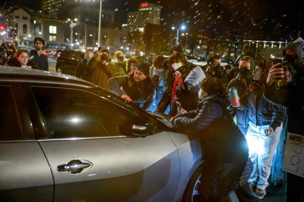 Protestors block a car they believed was driven by ICE agents escorting a detainee as it exited Hartford’s federal building, Jan. 8, 2026. Hundreds of protestors had gathered around the building for a vigil and protest against the killing of Renee Good in Minneapolis, Wednesday, Jan. 7, by ICE agents. (Mark Mirko/Connecticut Public)