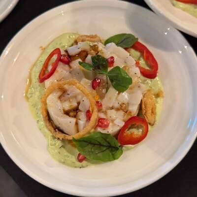The neon flying squid ceviche was served on a bed of avocado crema, along with mango pearls, fried shallots, hot peppers and pomegranate seeds. (Amy Kolb Noyes/CAI)