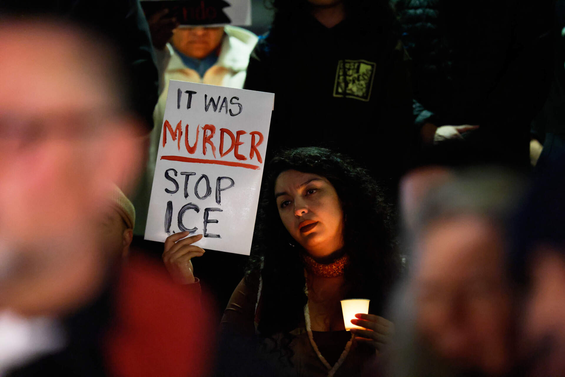 A demonstrator holds a sign during a candlelight vigil for Alex Pretti in Minneapolis on Jan. 24 in Los Angeles. (Caroline Brehman/AP)
