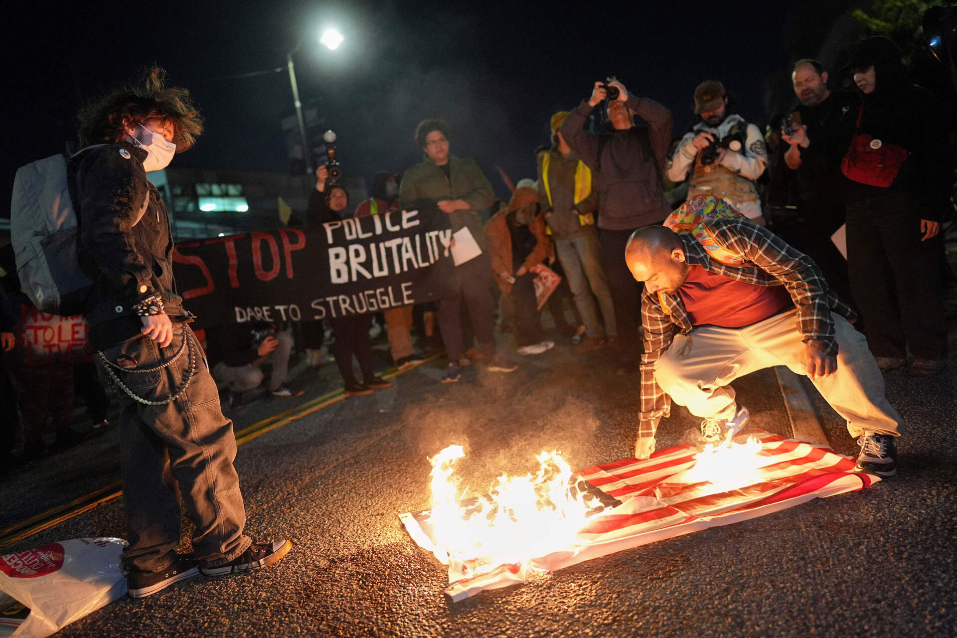 A protester burns an American flag in front of the Metropolitan Detention Center for the Federal Bureau of Prisons during a protest in Los Angeles on Thursday, Jan. 8, following the death of Renee Good, who was fatally shot by an ICE officer. (Jae C. Hong/AP)