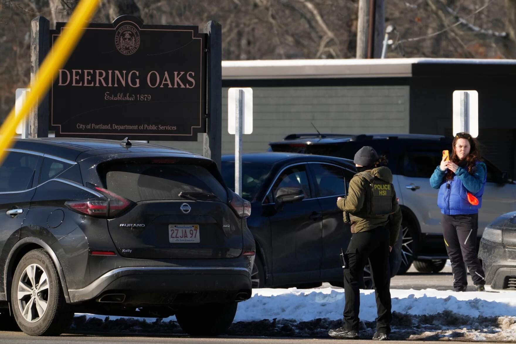 A woman films a Homeland Security Investigations agent at a parking lot at Deering Oaks Park, Friday, Jan. 23, 2026, in Portland, Maine. (Robert F. Bukaty/AP)