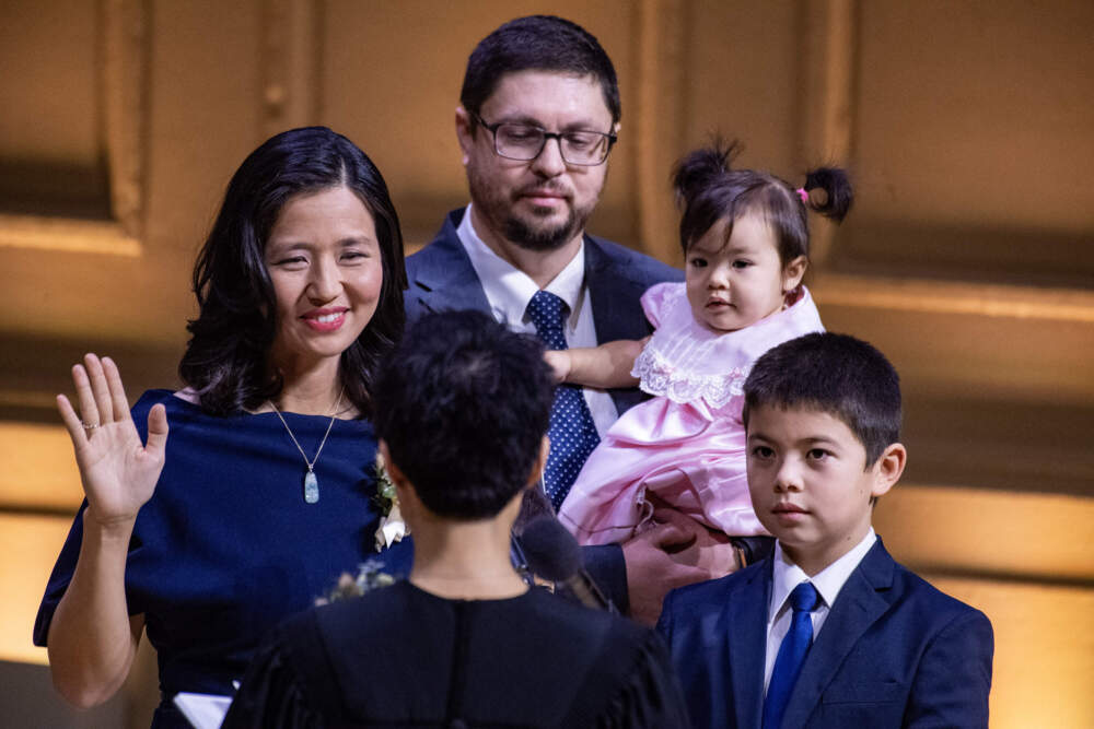 Boston Mayor Michelle Wu, left, is sworn in during her second-term inauguration alongside her husband and children. (Joseph Prezioso/AFP via Getty Images)