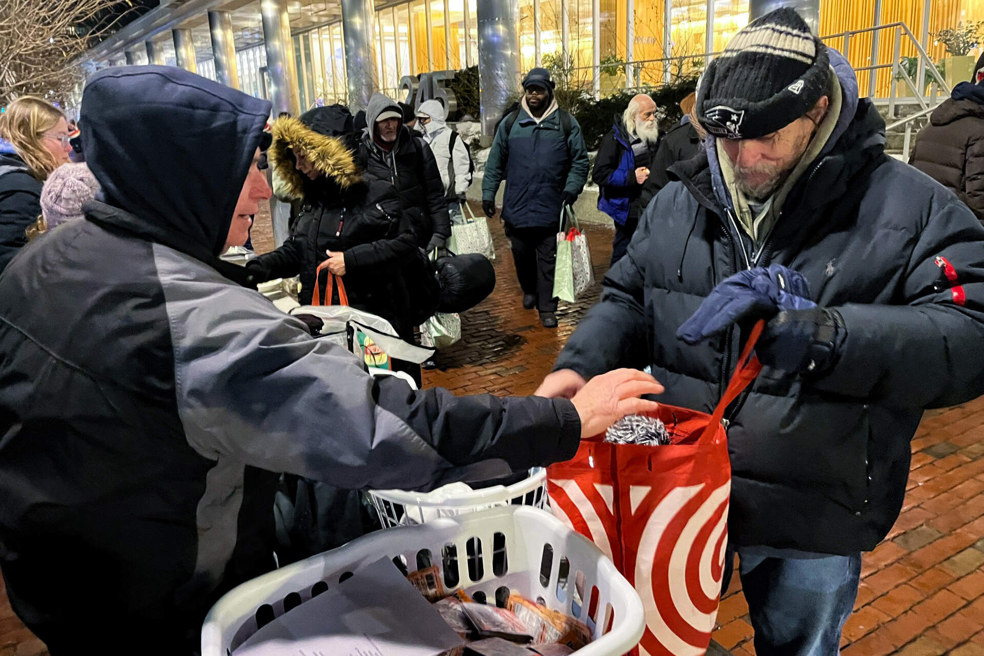 Bob MacMillian (right) gets socks and a hat from volunteer Peter Coleman (Lynn Jolicoeur/WBUR)