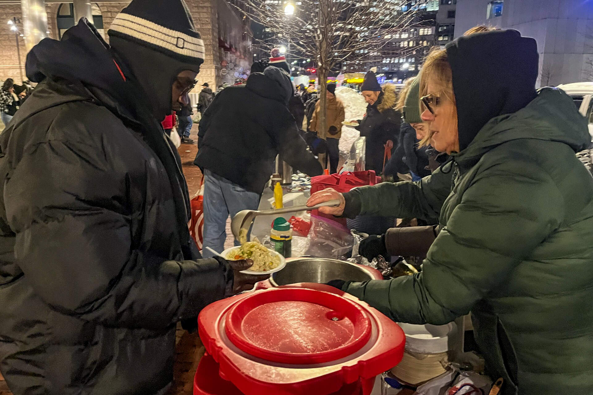 Elizabeth McCarty, a volunteer with COPE, gives out food made by the volunteers. (Lynn Jolicoeur/WBUR)