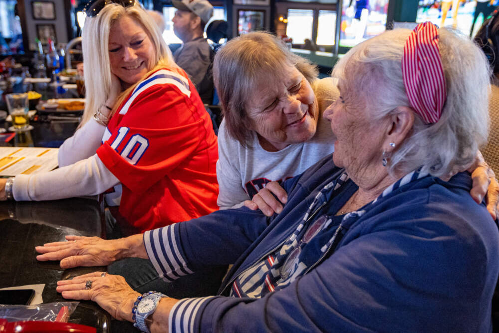 (Left to right) Leah Stevens, Jo-Anne Cutillo and Maureen 'Moe' Buckley-Walsh have a laugh at the bar at the Goat City Pub in Norton. (Jesse Costa/WBUR)