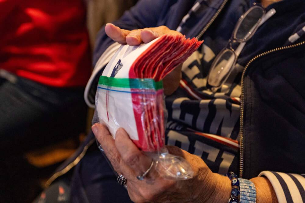 Buckley-Walsh hands out Patriots napkins to all of her friends on game day at the Goat City Pub. (Jesse Costa/WBUR)