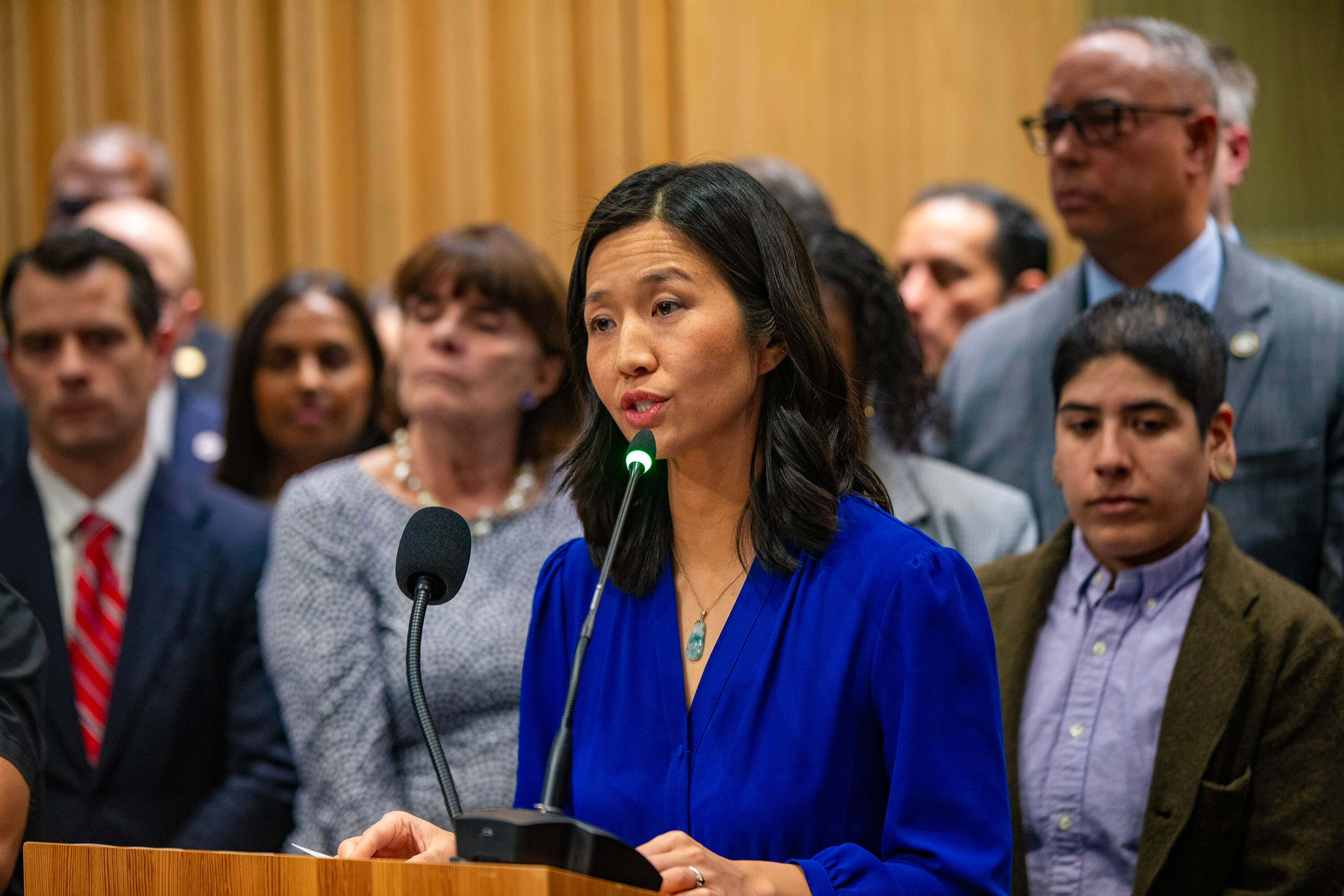 Boston Mayor Michelle Wu, joined by elected officials and organization leaders, announces she has signed an executive order which contains actions aimed at protecting residents and protesters from abuses by federal immigration agents. (Jesse Costa/WBUR)