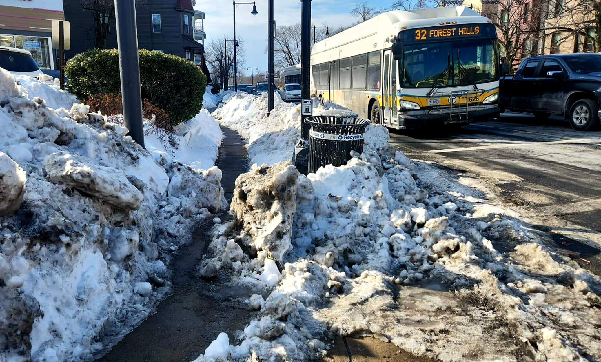 Snow accumulation at the intersection of Hyde Park Avenue and Walk Hill Street about a week and a half after a winter storm dumped two feet of snow on Boston. (Andrea Perdomo Hernandez/WBUR)